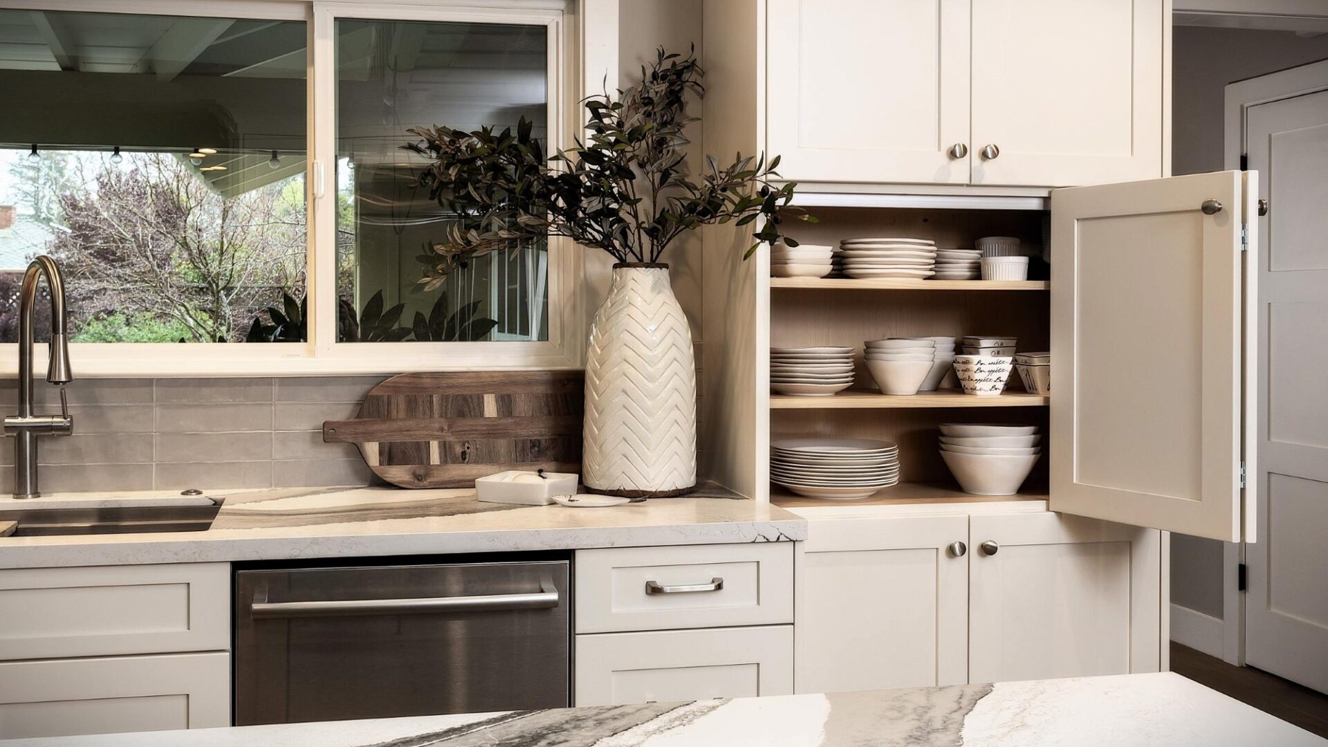 A stylish kitchen with white flat panel cabinets, beautifully organized